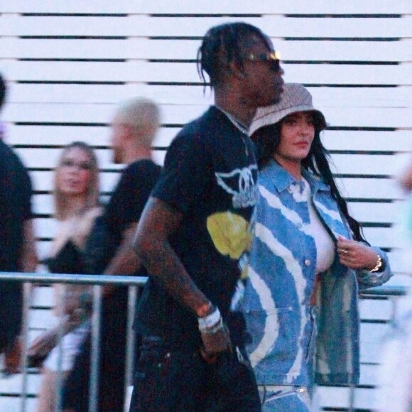 Exclusif - Kylie Jenner et son compagnon Travis Scott se rendent au festival Coachella, Kylie porte un bob beige et un ensemble en jean tye and dye. Indio, le 13 avril 2019.