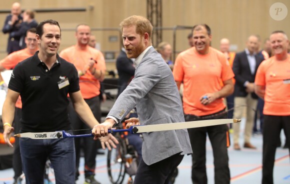Le prince Harry, duc de Sussex, fait du tir à l'arc lors de sa visite au Sportcampus Zuiderpark à La Haye le 8 mai 2019.