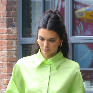 Kendall Jenner dans la rue à New York le 20 juin 2019. Elle porte une chemise oversized verte acidulée et des escarpins transparents.