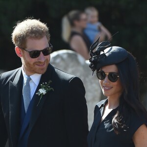 Le prince Harry et Meghan Markle, duchesse de Sussex, au mariage de Charlie Van Straubanzee et Daisy Jenkins en l'église Saint-Marie-La-Vierge à Frensham, le 4 août 2018.m