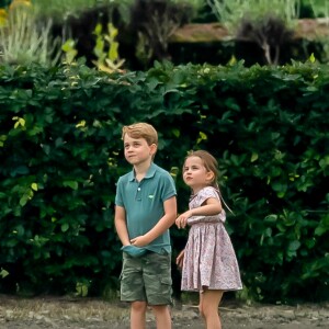 Le prince George de Cambridge et sa soeur la princesse Charlotte de Cambridge s'amusant pendant un match de polo disputé par le prince William à Wokinghan, le 10 juillet 2019.