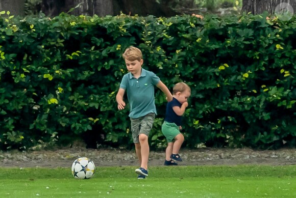 Le prince George de Cambridge et son frère le prince Louis de Cambridge s'amusant pendant un match de polo disputé par le prince William à Wokinghan, le 10 juillet 2019.