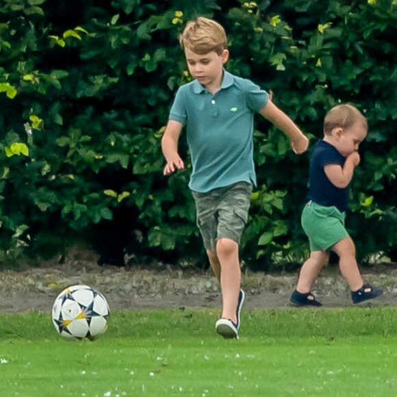 Le prince George de Cambridge et son frère le prince Louis de Cambridge s'amusant pendant un match de polo disputé par le prince William à Wokinghan, le 10 juillet 2019.