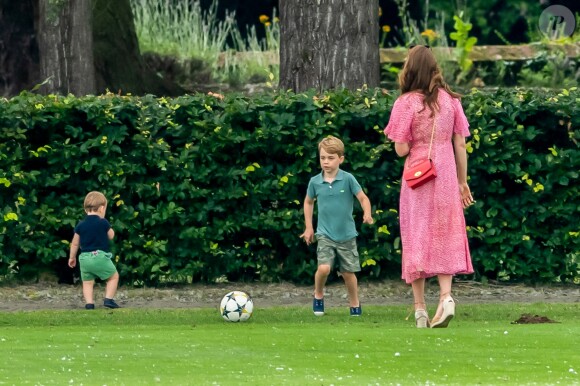 Le prince George de Cambridge et son frère le prince Louis de Cambridge s'amusant sous l'oeil de la duchesse Catherine pendant un match de polo disputé par le prince William à Wokinghan, le 10 juillet 2019.