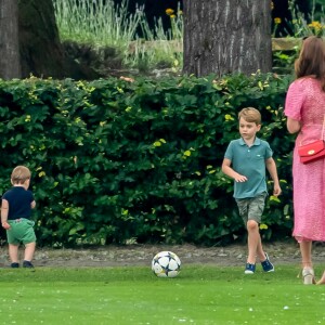 Le prince George de Cambridge et son frère le prince Louis de Cambridge s'amusant sous l'oeil de la duchesse Catherine pendant un match de polo disputé par le prince William à Wokinghan, le 10 juillet 2019.