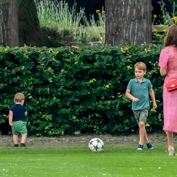 Le prince George de Cambridge et son frère le prince Louis de Cambridge s'amusant sous l'oeil de la duchesse Catherine pendant un match de polo disputé par le prince William à Wokinghan, le 10 juillet 2019.