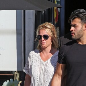 Exclusif - Britney Spears et son compagnon Sam Asghari sont allés déjeuner dans le restaurant 'Le Pain Quotidien' à Beverly Hills. Britney porte une blouse blanche transparente qui laisse entrevoir ses tétons. Le couple semble très amoureux, ils se tiennent la main alors qu'ils traversent la rue, le 12 juillet 2019.