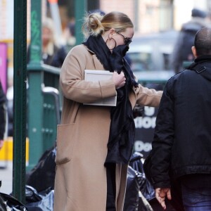 Adele se cache des photographes à la sortie d'un immeuble à New York, le 2 avril 2019.