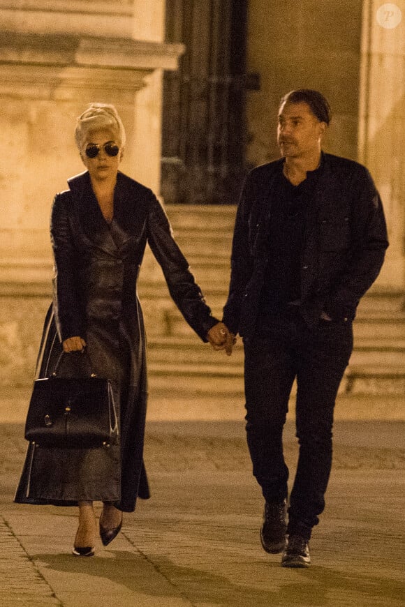Lady Gaga et Christian Carino quittent le restaurant Balagan et marchent devant la pyramide du musée Louvre à Paris le 29 aout 2018.