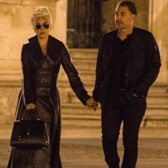 Lady Gaga et Christian Carino quittent le restaurant Balagan et marchent devant la pyramide du musée Louvre à Paris le 29 aout 2018.