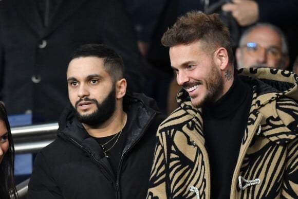 Malik Bentalha et Matt Pokora (M. Pokora) dans les tribunes du parc des Princes lors du match de football de ligue 1, opposant le Paris Saint-Germain (PSG) contre l'Olympique de Marseille (OM) à Paris, France, le 17 mars 2019.