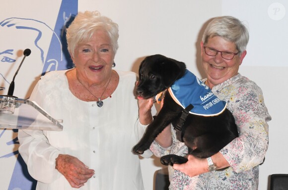 Line Renaud fait connaissance avec "Paris", un chiot d'Handi'Chiens, association qui a reçu un don de 15 000 euros, lors de la première édition de la remise du prix "Line Renaud - Loulou Gasté", pour la recherche médicale, à la Maison de la Recherche à Paris. Le 25 octobre 2019 © Coadic Guirec / Bestimage