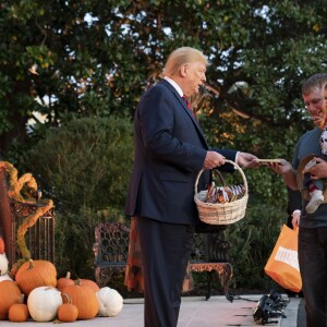 Le Président des Etats-Unis Donald Trump et sa femme Melania Trump donnent des bonbons aux enfants pour Halloween à la Maison Blanche à Washington, le 28 octobre 2019.