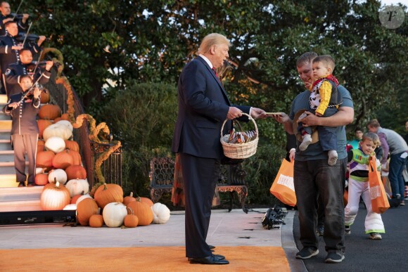 Le Président des Etats-Unis Donald Trump et sa femme Melania Trump donnent des bonbons aux enfants pour Halloween à la Maison Blanche à Washington, le 28 octobre 2019.