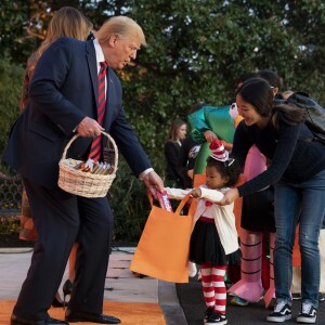 Le Président des Etats-Unis Donald Trump et sa femme Melania Trump donnent des bonbons aux enfants pour Halloween à la Maison Blanche à Washington, le 28 octobre 2019.