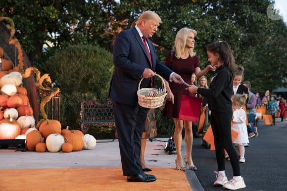 Le Président des Etats-Unis Donald Trump et sa femme Melania Trump donnent des bonbons aux enfants pour Halloween à la Maison Blanche à Washington, le 28 octobre 2019.