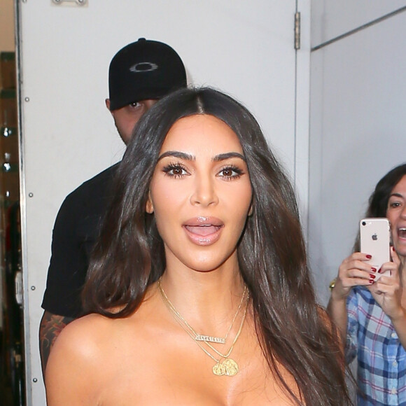 Kim Kardashian porte une robe longue moulante en satin à la sortie du magasin Ulta Beauty à New York, le 24 octobre 2019.