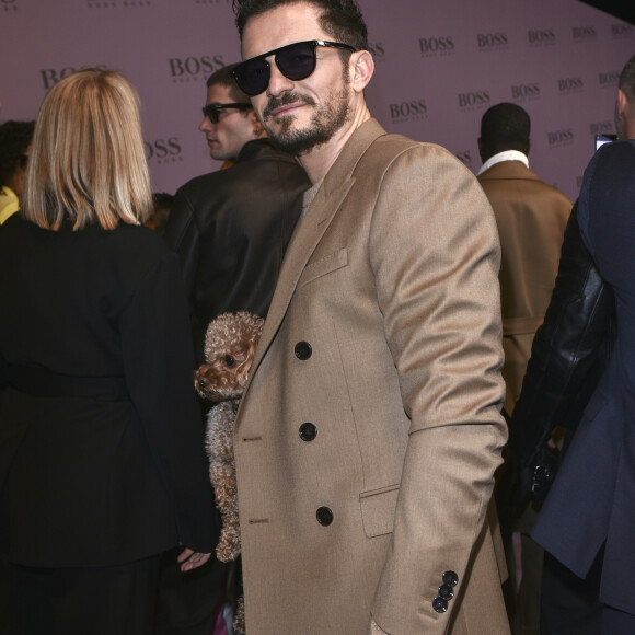 Orlando Bloom et son chien Mighty assistent au défilé de mode "BOSS" collection Automne-Hiver 2020-2021 lors de la fashion week à Milan, le 23 février 2020.
