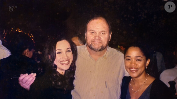 Les sourcils épilés, le teint mate et le crayon à lèvres : les tendances beauté des années 1990 sont bel et bien passées par Meghan Markle. Ici sur un portrait de famille avec ses parents Thomas Markle et Doria Ragland.