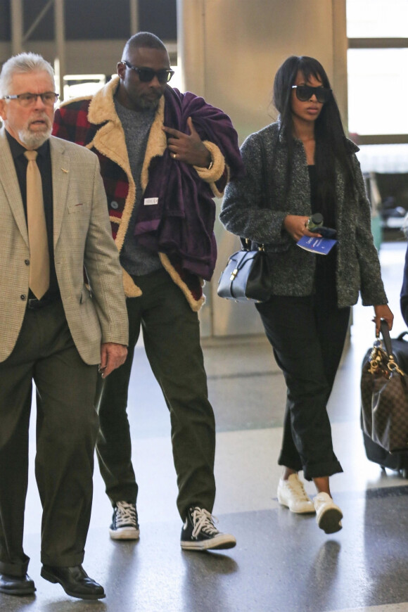 Exclusif - Idris Elba et sa fiancée Sabrina Dhowre arrivent à l'aéroport de LAX à Los Angeles pour prendre l'avion, le 23 janvier 2019.
