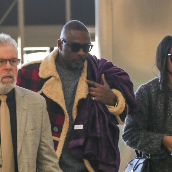 Exclusif - Idris Elba et sa fiancée Sabrina Dhowre arrivent à l'aéroport de LAX à Los Angeles pour prendre l'avion, le 23 janvier 2019.