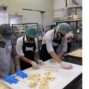 Meghan Markle et le prince Harry en cuisine pour l'association californienne Homeboy Industries, le 23 juin 2020.