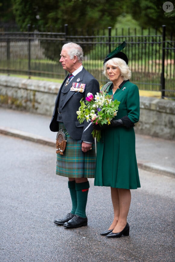 Le prince Charles, prince de Galles, et Camilla Parker Bowles, duchesse de Cornouailles, observent deux minutes de silence dans le cadre de la commémoration du 75ème anniversaire de la victoire du 8 mai 1945 devant le mémorial de Balmoral, le 8 mai 2020.