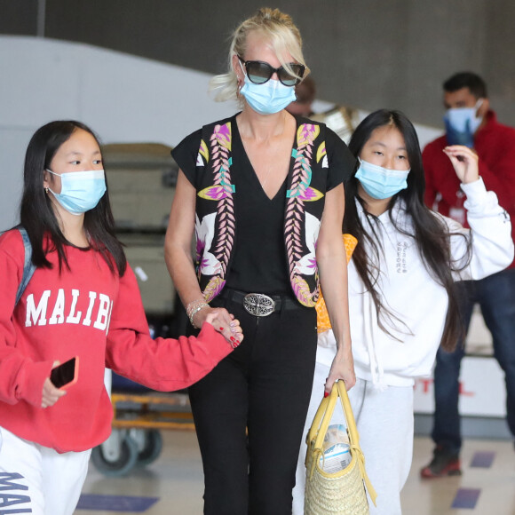 Laeticia Hallyday et ses filles Jade et Joy arrivent, avec des masques de protection contre l'épidémie de coronavirus (Covid-19), à l'aéroport de Paris-Charles-de-Gaulle à Roissy-en-France, France, le 18 juin 2020.