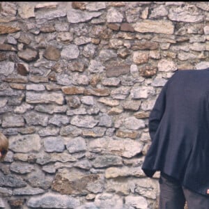 Alain Delon et Mireille Darc sur la tombe de Romy Schneider à Boissy-sans-Avoir dans les Yvelines, en 1982. 