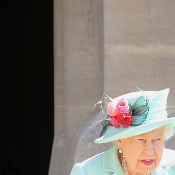 La reine Elisabeth II d'Angleterre remet au capitaine Thomas Moore son titre de chevalier lors d'une cérémonie au château de Windsor, le 17 juillet 2020.