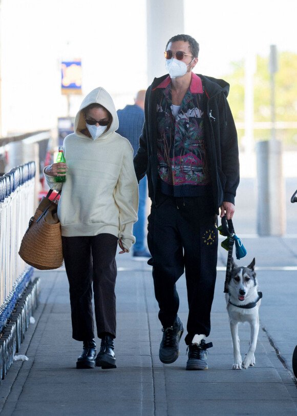 Exclusif - Zoe Kravitz et son mari Karl Glusman au départ de l'aéroport JFK avec leur chien Scout à New York le 31 aout 2020. L'actrice de 31 ans portait un grand sac de paille et un débardeur bleu, un pantalon marron et des bottes The Row. Le couple se rend à Londres où Zoe est attendue sur le tournage du film "The Batman".