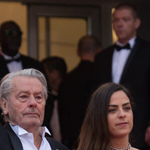 Alain Delon (Palme d'Or d'Honneur du 72ème festival de Cannes avec un badge Paris Match d'une ancienne couverture du magazine titrant "Alain Delon, mes deux amours, Rosalie et Anouchka) et sa fille Anouchka (Robe Elie Saab) - Montée des marches du film "A Hidden Life" lors du 72ème Festival International du Film de Cannes. Le 19 mai 2019