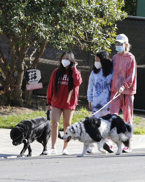 Laeticia Hallyday, ses filles Jade et Joy, avec des masques, et leurs chiens Santos, Cheyenne et Bono se promènent dans le quartier de Pacific Palisades, à Los Angeles, Californie, Etats-Unis, le 3 avril 2020, pendant la période de confinement.