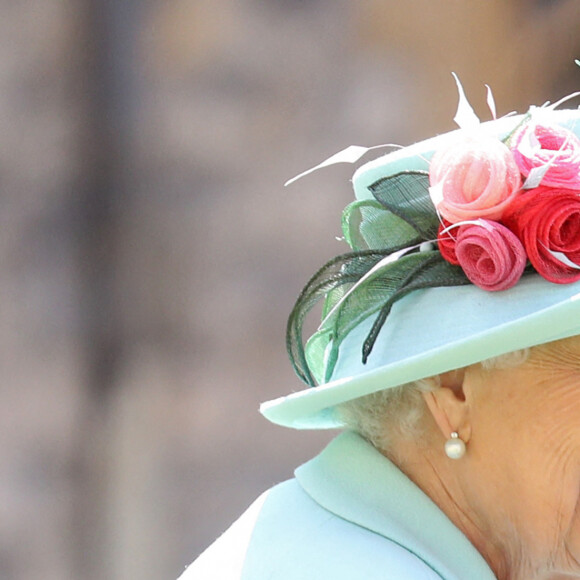 La reine Elisabeth II d'Angleterre remet au capitaine Thomas Moore son titre de chevalier lors d'une cérémonie au château de Windsor, le 17 juillet 2020. Il pose ensuite avec sa famille.