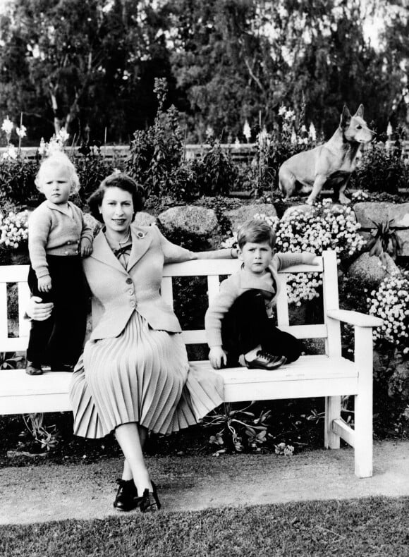 La reine Elizabeth II, la princesse Anne et le prince Charles posant à Balmoral en 1953... avec la participation du corgi Sue !