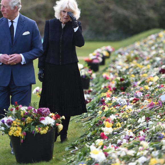 Le prince Charles, prince de Galles et la duchesse de Cornouailles Camila Parker-Bowles passent en revue les hommages au prince Philip dans les jardins de Marlborough House à Londres le 15 avril 2021.