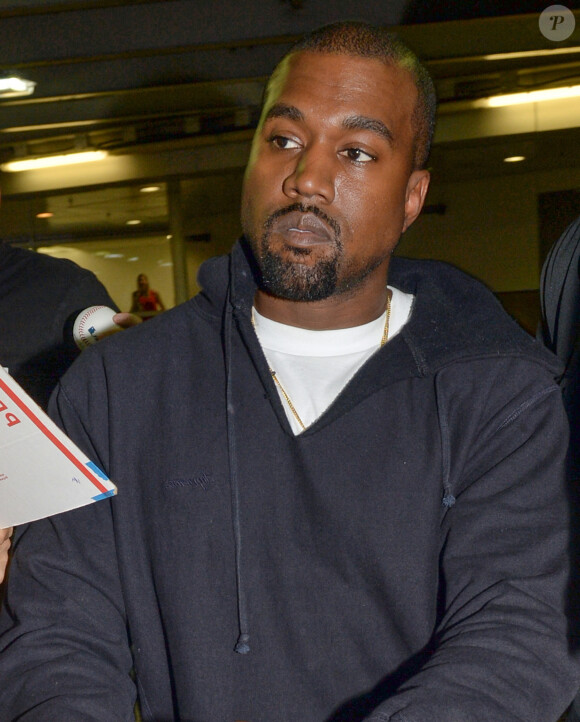 Kanye West arrive à l'aéroport de Miami. Il signe des autographes à ses fans, et même les baskets de sa marque