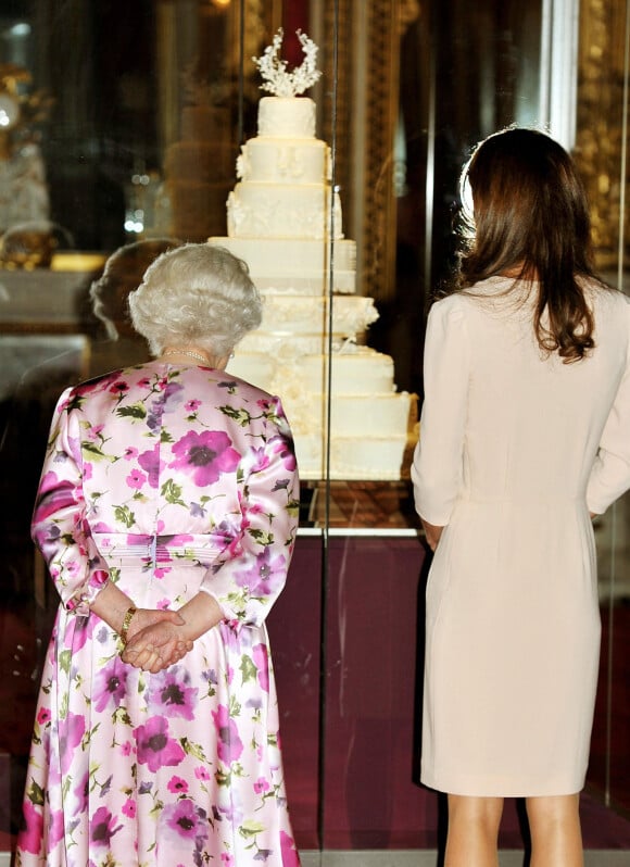 Kate Middleton devant la réplique de son gâteau de mariage avec la reine Elizabeth II, le 22 juin 2011 au palais de Buckingham.