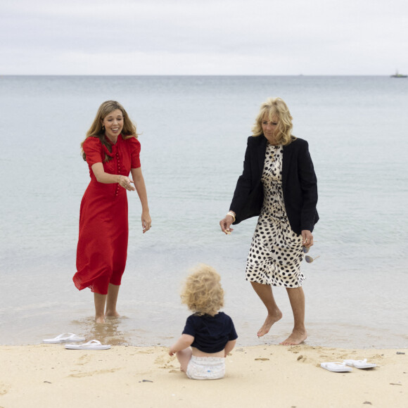 Carrie Johnson s'entretient avec la Première Dame des États-Unis, Jill Biden, lors du sommet des dirigeants du G7 à Carbis Bay, alors que Wilfred Johnson est assis sur la plage. 10 juin 2021