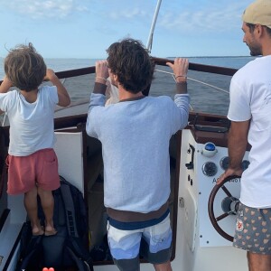 Jérémy Frérot un ami et son fils Lou sur un bateau en pleine mer, le 23 août 2021.