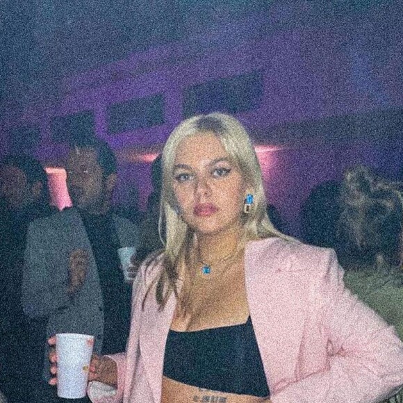 Louane chic dans son ensemble rose et sa mini-brassière.