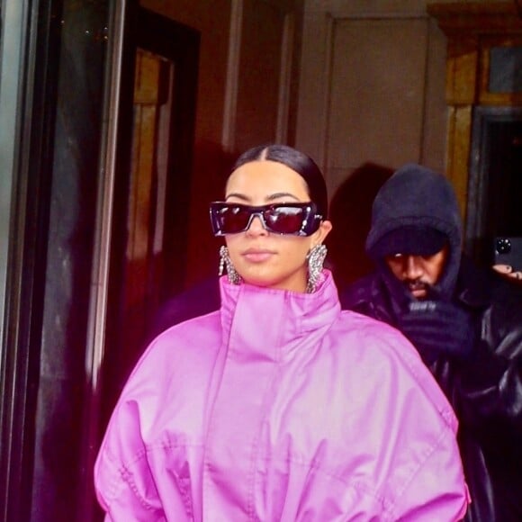 Kim Kardashian (emmitouflée dans un long manteau rose) et Kanye West sortent ensemble de l'hôtel Ritz Carlton pour se rendre dans les studios de l'émission "Saturday Night Live" (SNL) à New York, le 9 octobre 2021. 