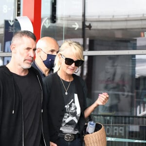 Exclusif - Laeticia Hallyday et ses filles Jade et Joy arrivent à l'aéroport de Roissy-Charles-de-Gaulle à Paris, le 27 juin 2021. Son compagnon Jalil Lespert lui a fait la surprise de venir l'accueillir à l'aéroport. Laeticia porte un t-shirt à l'effigie de Johnny Hallyday.