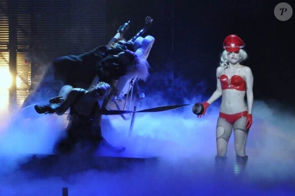 Quand elle joue les flicquettes sexy en combi cuir rouge sur un divan, Lady Gaga... on ne lui résiste pas lors de son show à l'Université Centrale de Floride le 3 janvier 2010 !