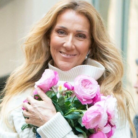 Celine Dion rayonnante et très souriante dans un ensemble pull écru et jupe bouffante fleurie salue ses fans à la sortie de son hôtel à New York,