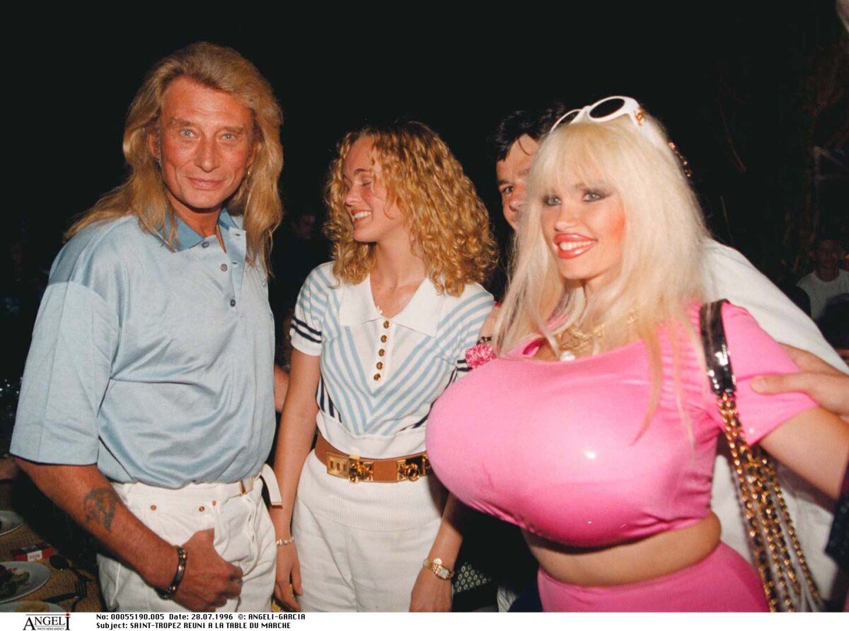 Photo : Johnny Hallyday, Laeticia Hallyday et Lolo Ferrari à la Table du  marché. Saint-Tropez. Le 28 juillet 1996. - Purepeople