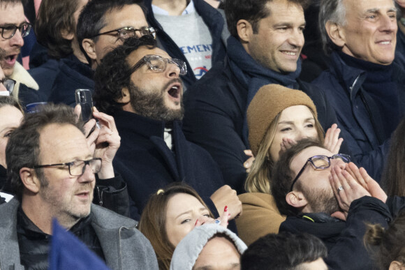 Maxim Nucci (Yodelice) et sa compagne Isabelle Ithurburu assistent à la rencontre de rugby opposant la France à l'Angleterre, au stade de France, dans le cadre du Tournoi des Six Nations. Saint-Denis, le 19 mars 2022. © Cyril Moreau/Bestimage