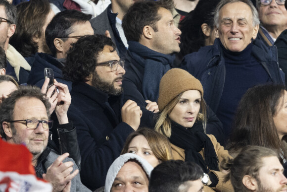 Maxim Nucci (Yodelice) et sa compagne Isabelle Ithurburu assistent à la rencontre de rugby opposant la France à l'Angleterre, au stade de France, dans le cadre du Tournoi des Six Nations. Saint-Denis, le 19 mars 2022. © Cyril Moreau/Bestimage