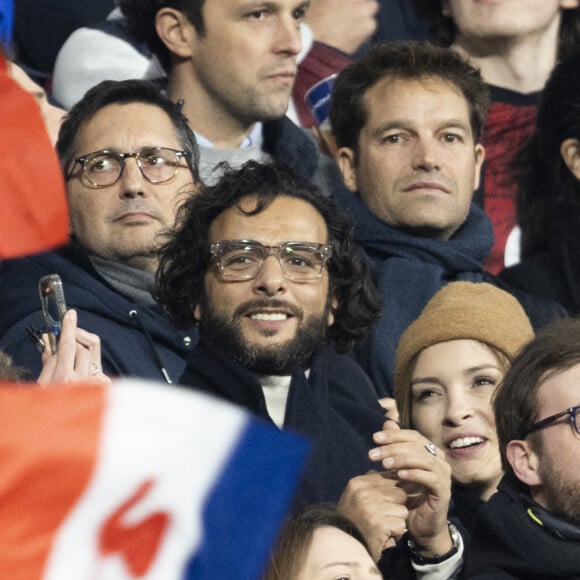 Maxim Nucci (Yodelice) et sa compagne Isabelle Ithurburu assistent à la rencontre de rugby opposant la France à l'Angleterre, au stade de France, dans le cadre du Tournoi des Six Nations. Saint-Denis, le 19 mars 2022. © Cyril Moreau/Bestimage