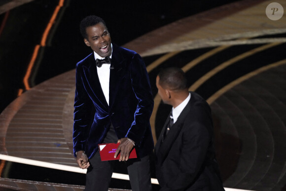 Will Smith frappant violemment Chris Rock sur la scène des Oscars le 27 mars 2022 après la blague déplacée de l'humoriste sur l'alopécie de Jada Pinkett-Smith